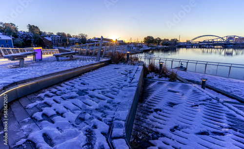 Early morning in city by river with fresh snow 