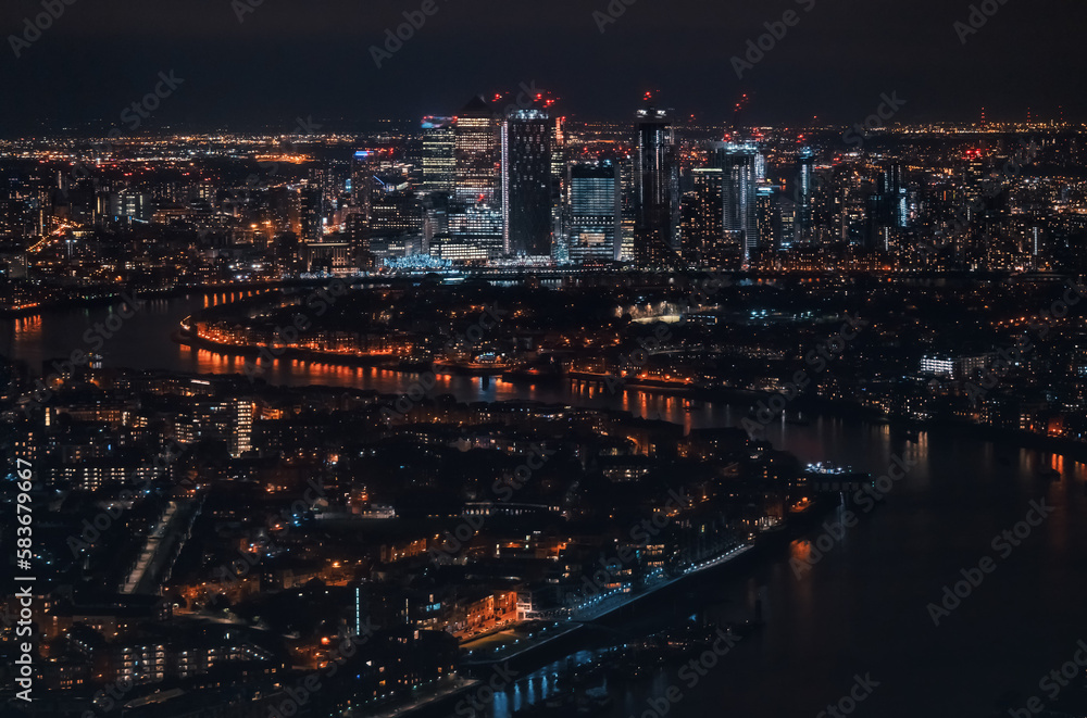 Aerial view of London at night, north eastern part, Isle of Dogs on river Thames, with Canary Wharf financial district