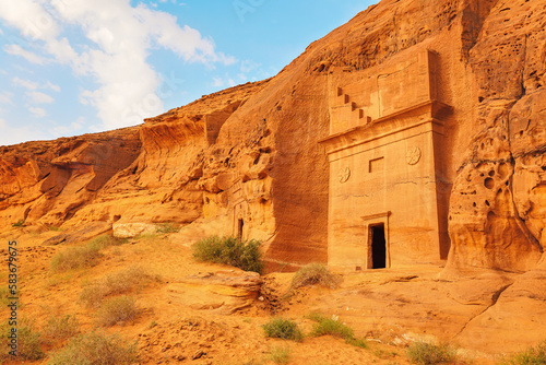 Old Nabatean architecture carved on orange sandstone wall at Jabal Al Ahmar, Hegra in Saudi Arabia, 18 ancient tombs are located here, 111 in whole Mada in Salih archaeological site photo