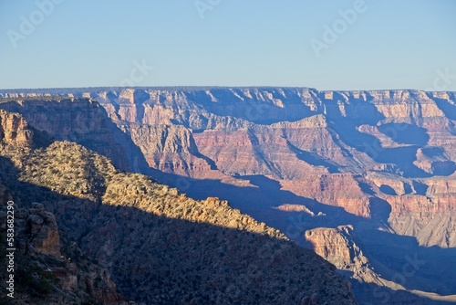 Early morning light casts shadows in the deeply eroded Grand Canyon, carved by the Colorado River thousands of feet below