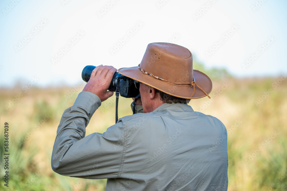 a man with a cowboy hat looking through his camera a man with a cowboy hat looking through his camera