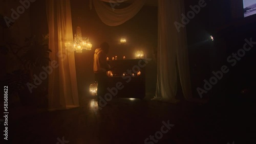 The witch summons ancient powers with black candles in a dark background, performing a mystic rite with voodoo and paganism. The close-up captures the magic and mysticism of the ritual