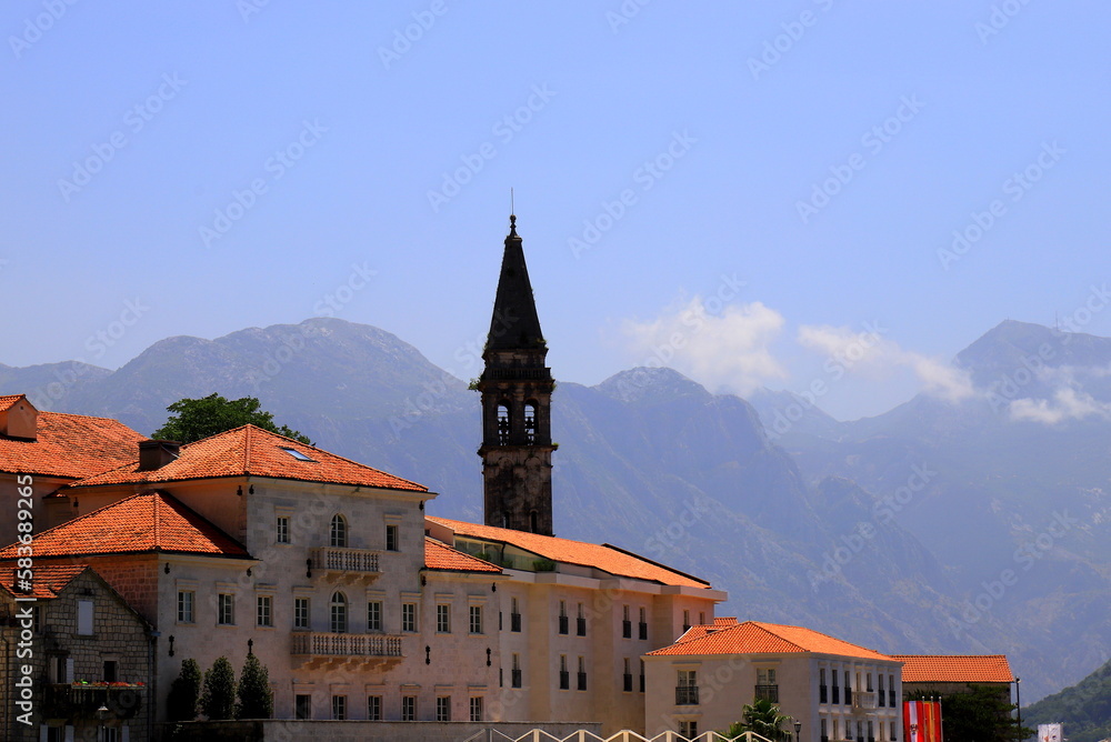 Old buildings and towers in Perast, Montenegro at sunrise. A beautiful resort town in Kotor Bay in summer, high mountains. Adriatic Sea, Montenegro