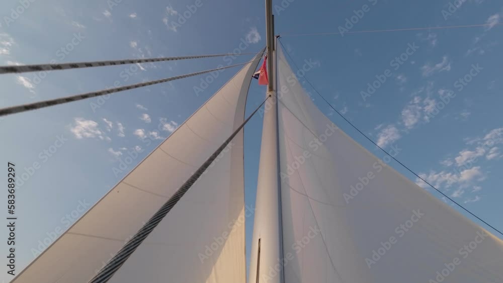 4K Sailboat Mast and Sail. Open, unfurled sails on a yacht. Sailing in the wind. Full sails