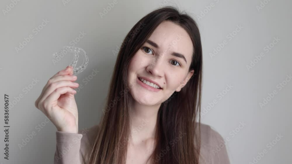 A young girl uses aligners to straighten her teeth A young girl uses aligners to straighten her teeth