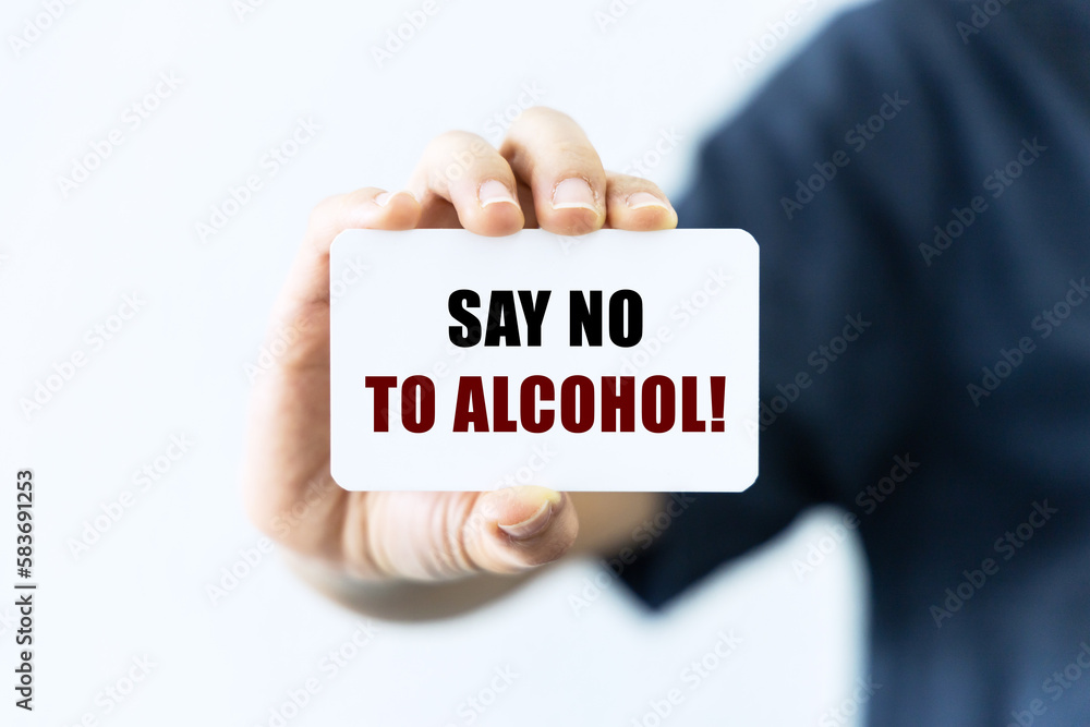 Say no to alcohol text on blank business card being held by a woman's hand with blurred background. Business concept about stop drinking. Say no to alcohol text on blank business card being held by a woman's hand with blurred background. Business concept about stop drinking.