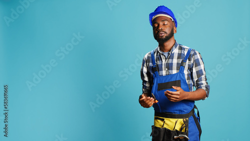 Dizzy construction worker feeling light headed in studio, almost fainting and having cartoonish stars above his head. Male contractor with hardhat being disoriented and unsteady, looney tunes.