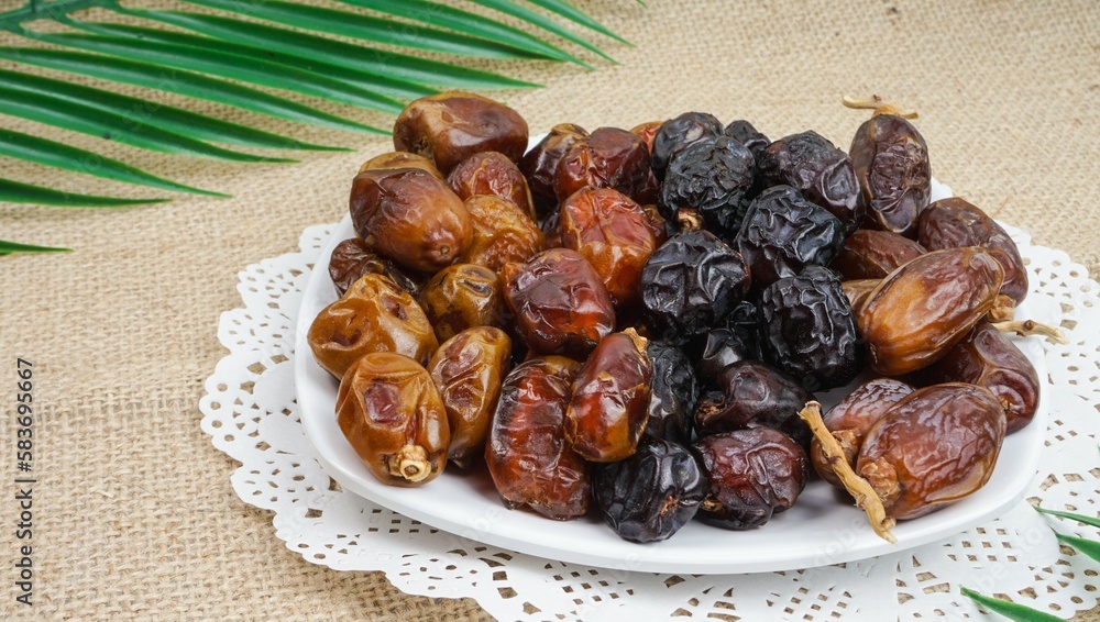Dates or dattes palm fruit in wooden plate is snack healthy, Set of various dates in white plate Dates or dattes palm fruit in wooden plate is snack healthy, Set of various dates in white plate