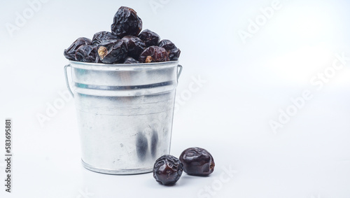 Ajwa Kurma or Dried date fruits in a metal mini-bucket.