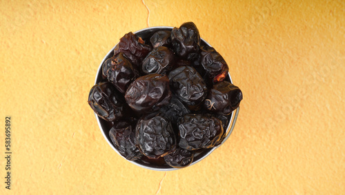 Ajwa Kurma or Dried date fruits in a metal mini-bucket.