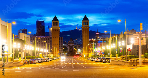 Scenic night view of illuminated Avinguda de la Reina Maria Cristina in Barcelona leading to Placa de Espana with two Venetian Towers on either side of avenue, Spain photo