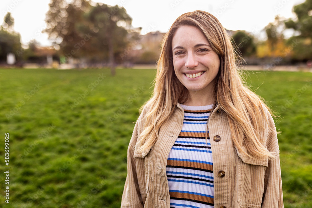 Portrait of young caucasian woman smiling at camera standing at city park. Portrait of young caucasian woman smiling at camera standing at city park.