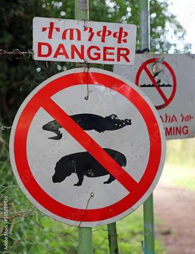 Cartel de peligro alertando cocodrilos e hipopotamos en el Lago Chamo de Etiopia photo
