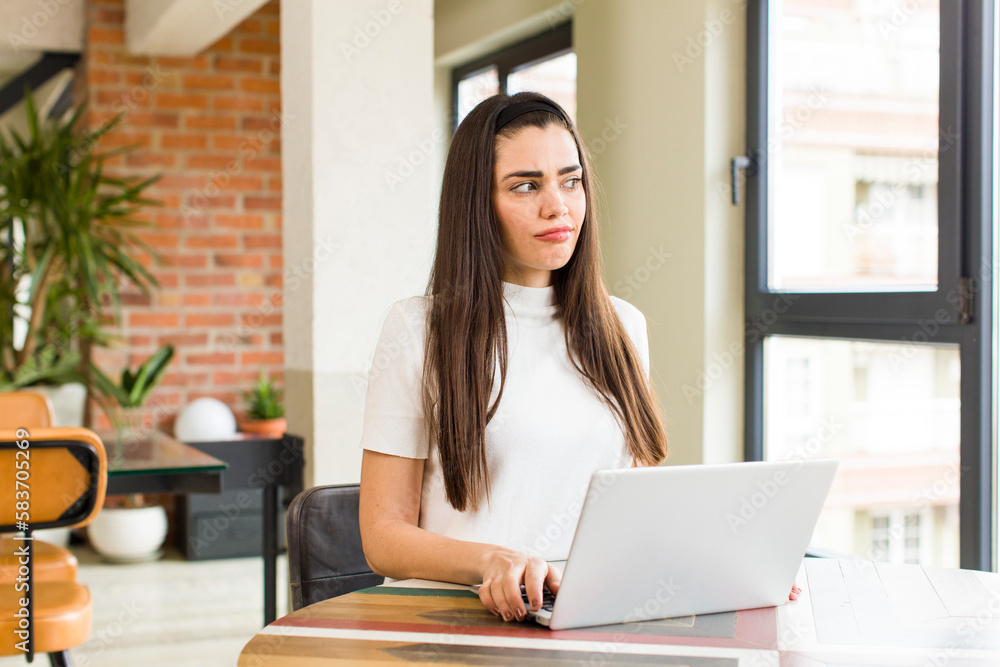 pretty young woman with a laptop working at home. house interior design pretty young woman with a laptop working at home. house interior design