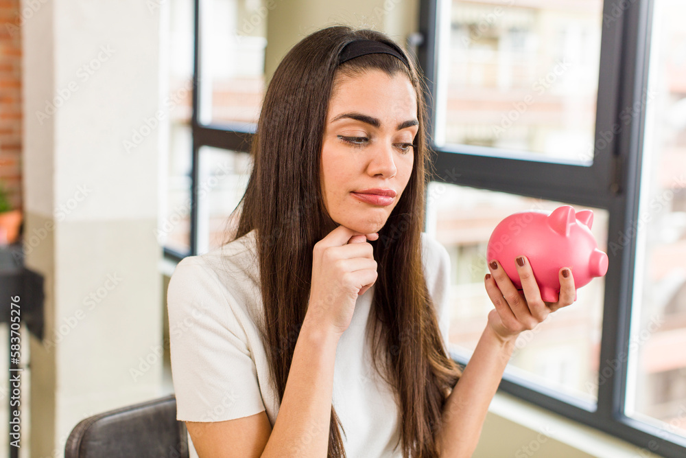 pretty young woman with a piggy bank. savings concept. house interior design pretty young woman with a piggy bank. savings concept. house interior design