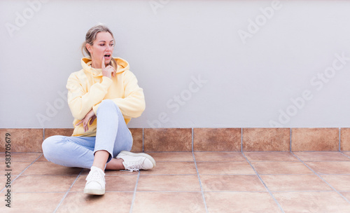 pretty caucasian sitting woman with surprised, nervous, worried or frightened look, looking to the side towards copy space