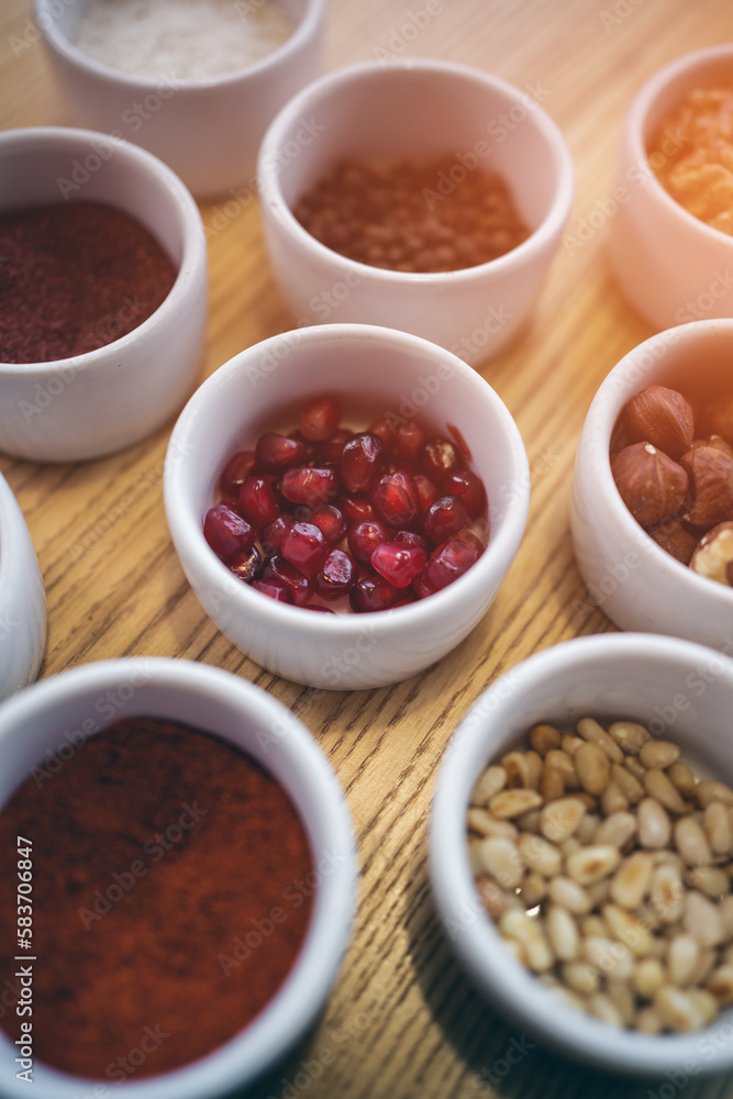 set of spices on wooden background, paprika, pomegranate, pine nut, hazelnut set of spices on wooden background, paprika, pomegranate, pine nut, hazelnut