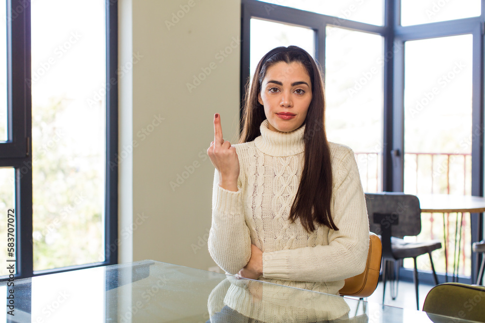 pretty caucasian woman feeling angry, annoyed, rebellious and aggressive, flipping the middle finger, fighting back