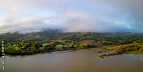 Panoramic aerial view of fog and dawn sun light on green hills of California © Osaze