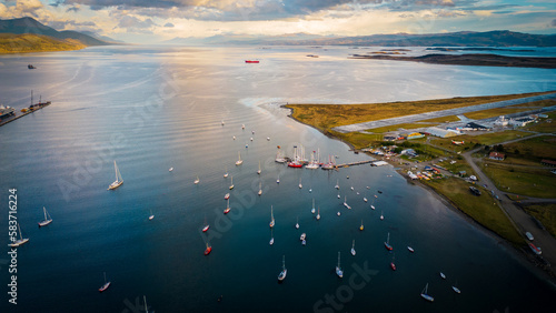 City of Puerto Natales Chile, Aerial Drone Above Town Buildings Amongst Patagonian Landscape of Idyllic Bay Water and Andean Cordillera Background photo