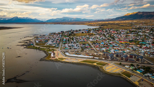 City of Puerto Natales Chile, Aerial Drone Above Town Buildings Amongst Patagonian Landscape of Idyllic Bay Water and Andean Cordillera Background photo