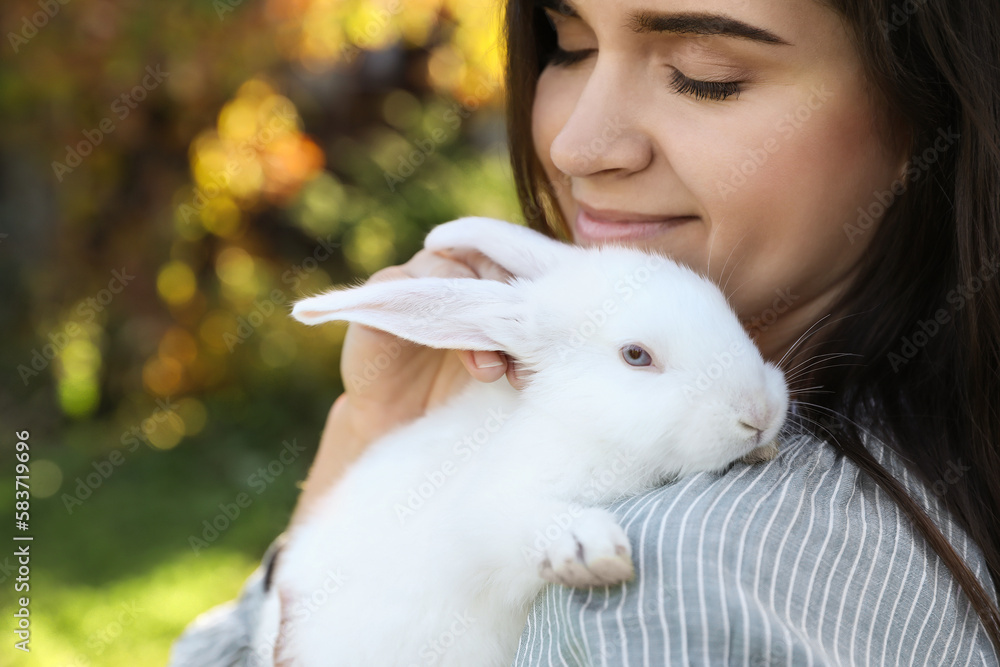 Happy woman with cute rabbit outdoors on sunny day, closeup. Space for text Happy woman with cute rabbit outdoors on sunny day, closeup. Space for text