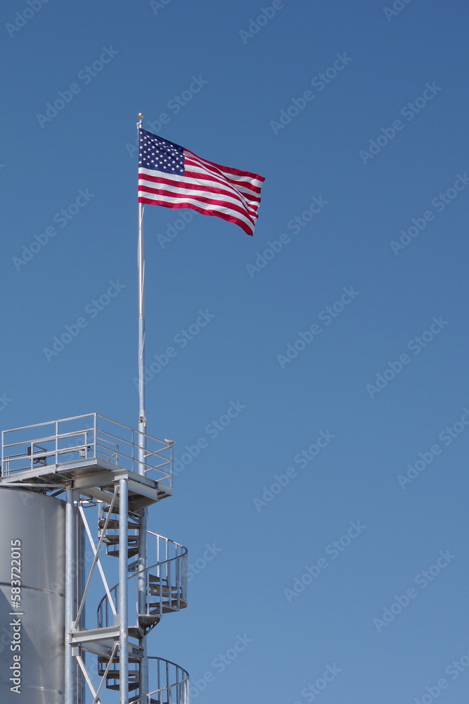 Fototapeta premium American Flag over an industrial structure