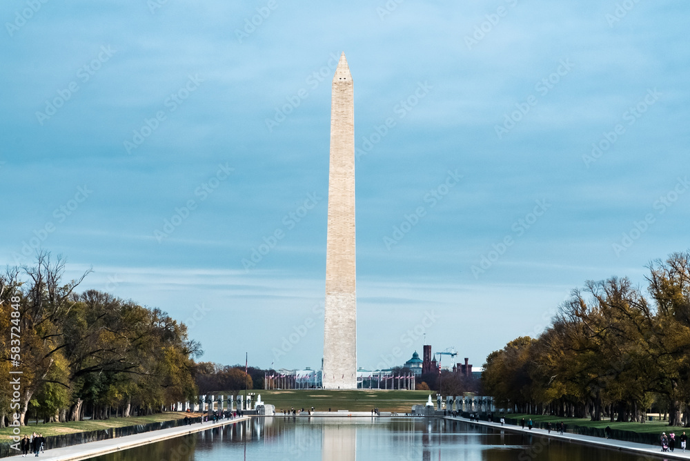 Washington D. C.  United States. November 29, 2022: Washington Monument with blue sky and reflection in the water.