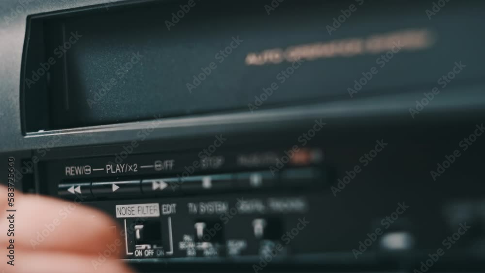 Eject VHS tape cassette from VCR player. Male hand pushes a button and