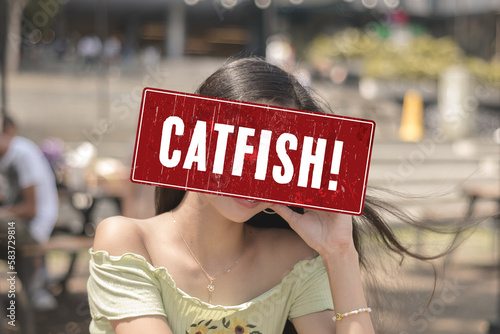 A catfish alert sign or someone pretending to be an attractive person. A fake profile using a stolen photo. A false identity used to pursue deceptive online romance. Catfishing detection concept. © Mdv Edwards