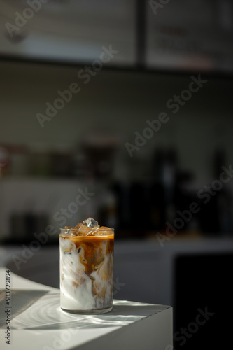 A glass of iced coffee with a green background