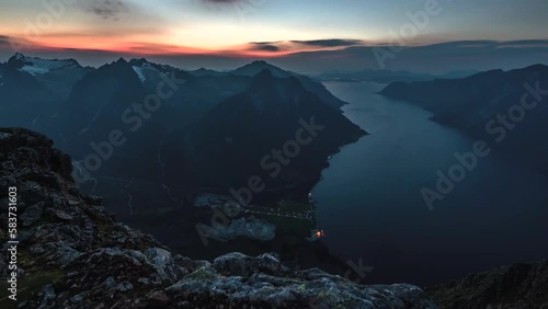 A timelapse from the top of a mountain with a large view, river and mountains at sunset time. Norway. photo