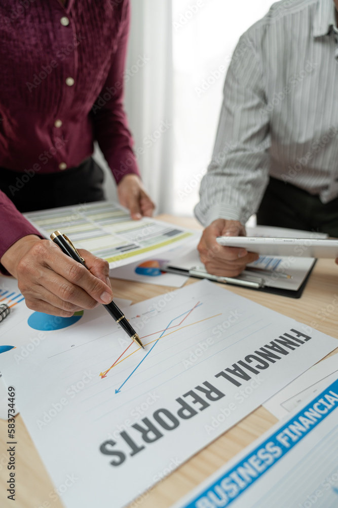 A group of Asian businessmen are brainstorming to analyze financial reporting situations. Calculate investments, income, taxes, accounts from data reference graphs. Income from laptop at office desk. A group of Asian businessmen are brainstorming to analyze financial reporting situations. Calculate investments, income, taxes, accounts from data reference graphs. Income from laptop at office desk.