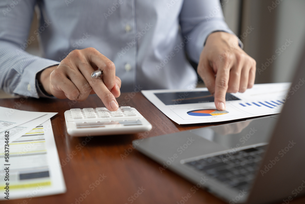 asian business man working with hand pointing graph discussion and analysis data charts and graphs and using a calculator to calculate numbers. Business finances and accounting concept. asian business man working with hand pointing graph discussion and analysis data charts and graphs and using a calculator to calculate numbers. Business finances and accounting concept.