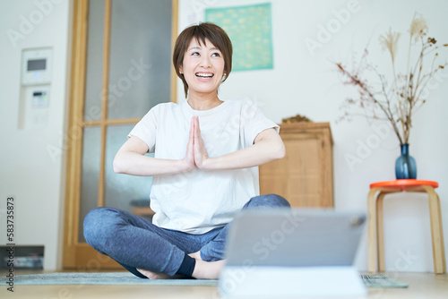 Free Download タブレットPCの画面を見ながら部屋でストレッチする女性 - GFXLoad