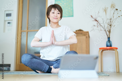 Free Download タブレットPCの画面を見ながら部屋でストレッチする女性 - GFXLoad