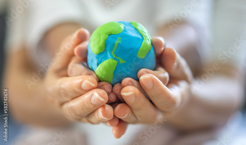 Hand of mother and kid child holding planting care saving clean energy earth globe world environment green eco friendly.campaign save the earth and earth Day 22 April
