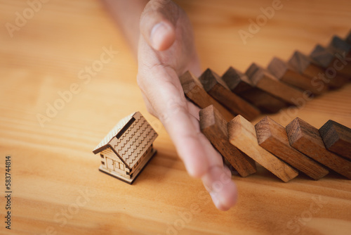 Tablou pe pânză businessman hand protect home from domino effect, insurance and contingency plan