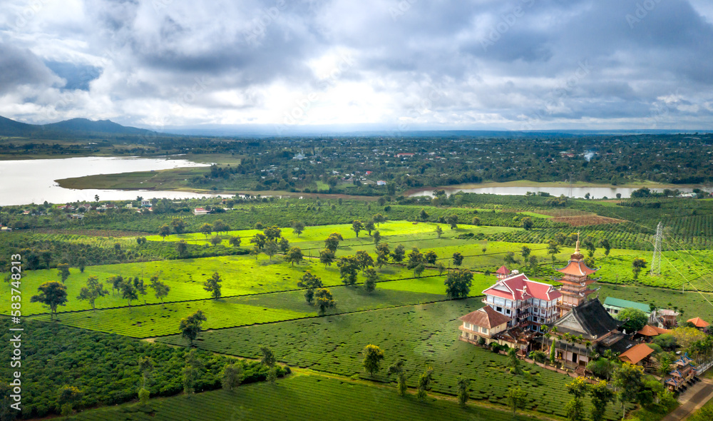 Naklejka premium Aerial view of an ancient pagoda in the middle of a green tea field in Pleiku town, Gia Lai province, Vietnam