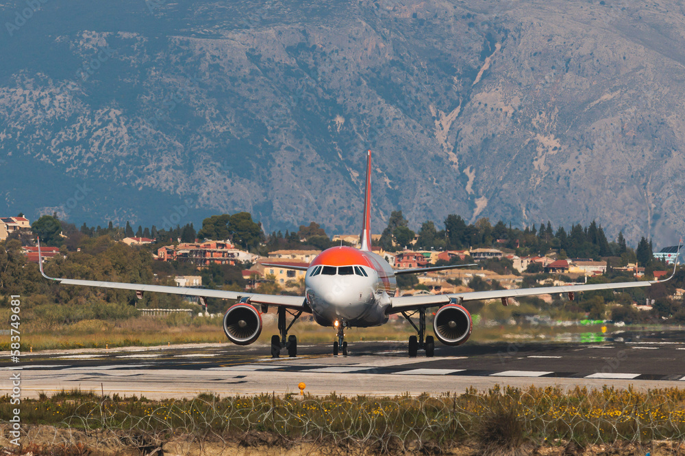 Fototapeta premium View of modern passenger plane aircraft on an runway airfield ready to take off, airstrip with commercial airplane before take off or after landing, airliner with mountains in a summer day