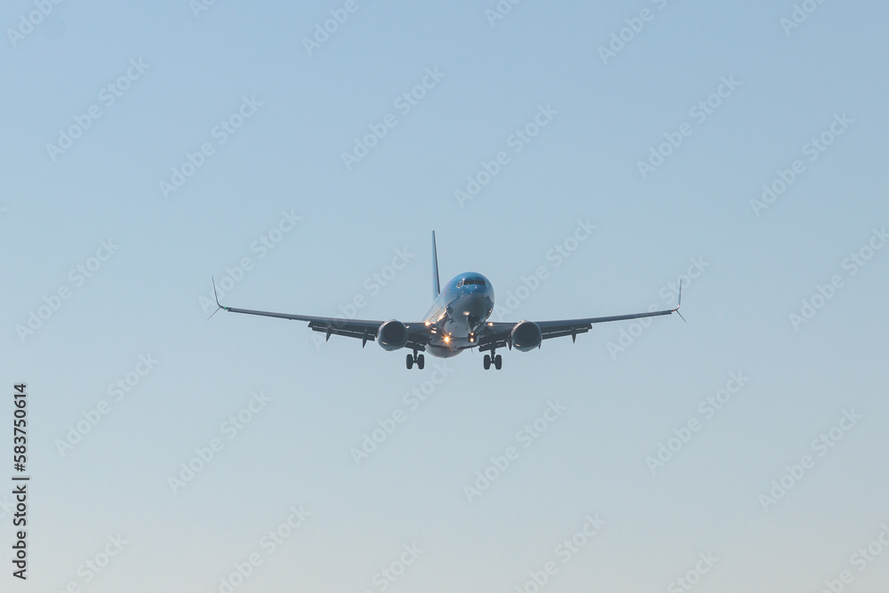 View of modern passenger plane aircraft in flight, commercial airplane flying in the sky before take off or landing, with mountains in the background in a summer sunny day View of modern passenger plane aircraft in flight, commercial airplane flying in the sky before take off or landing, with mountains in the background in a summer sunny day