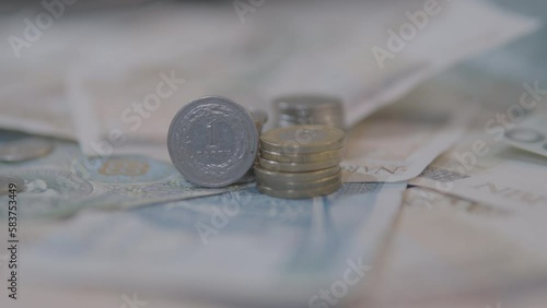 Stack Of Polish Coins Over Paper Banknote In The Table. - tilt up, selective fous photo