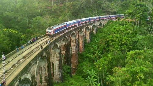 Aerial drone 4k. Scenic train on Nine Arch Bridge. Kandy to Ella railway. South Asia summer tourism.