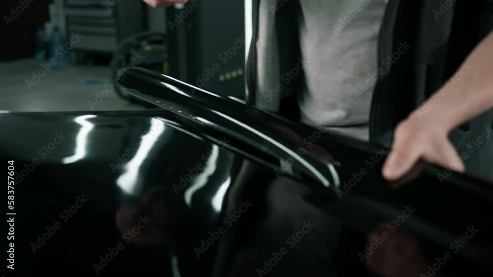 Gluing the film on the spoiler to protect the paint which protects the