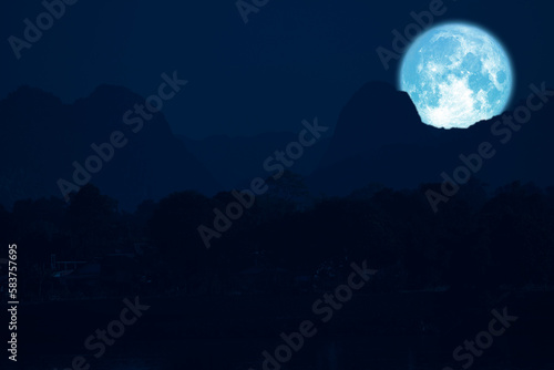 rose moon on night sky back over silhouette mountain