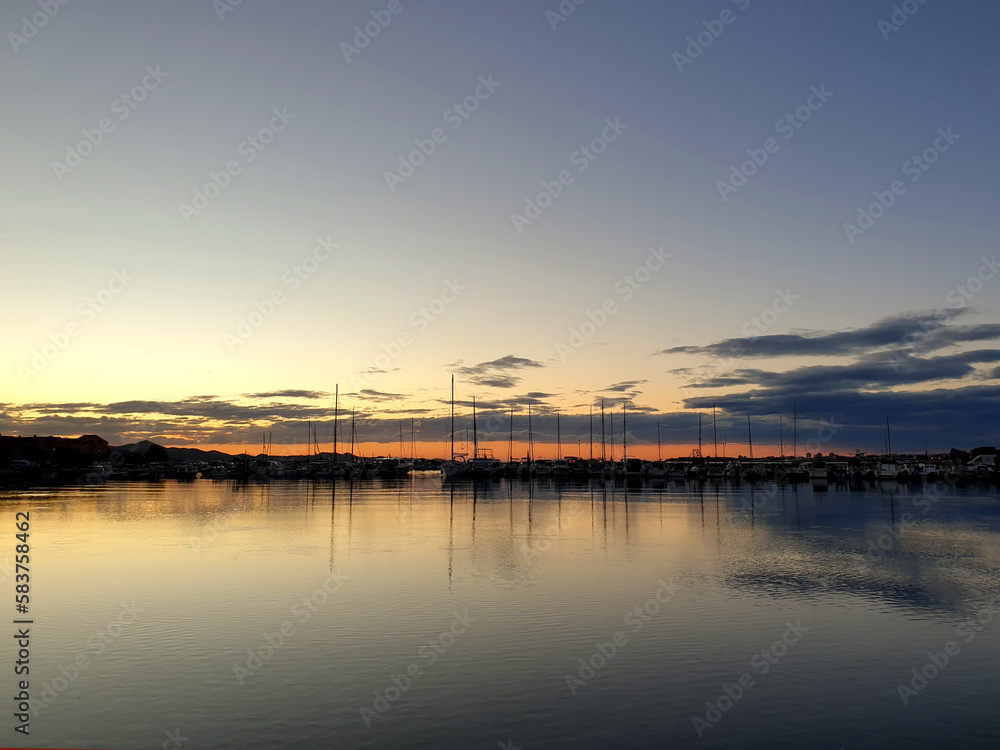 sunset sky over water with boats in marina sunset sky over water with boats in marina