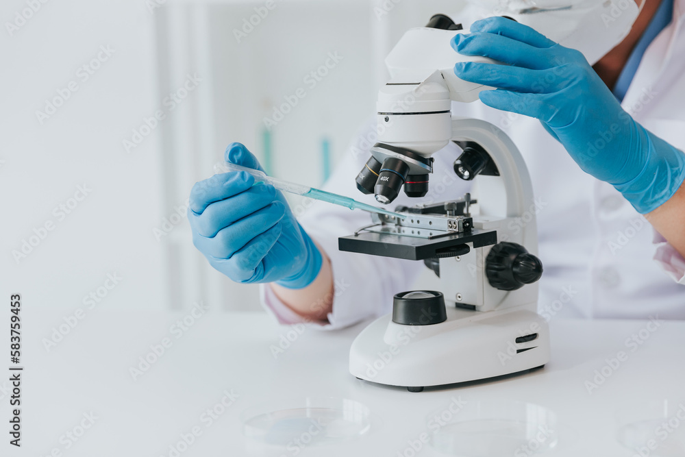 Scientist or doctor wear medical protective mask looking at blood samples under microscope. Scientist or doctor wear medical protective mask looking at blood samples under microscope.