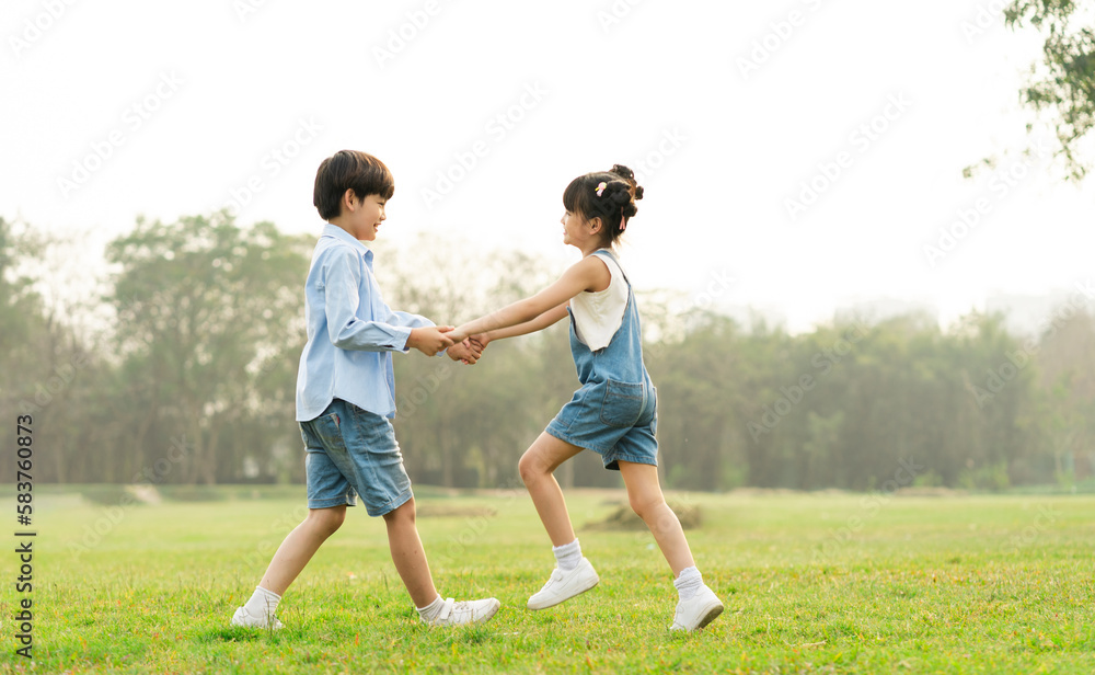 image of brother and sister having fun in the park image of brother and sister having fun in the park