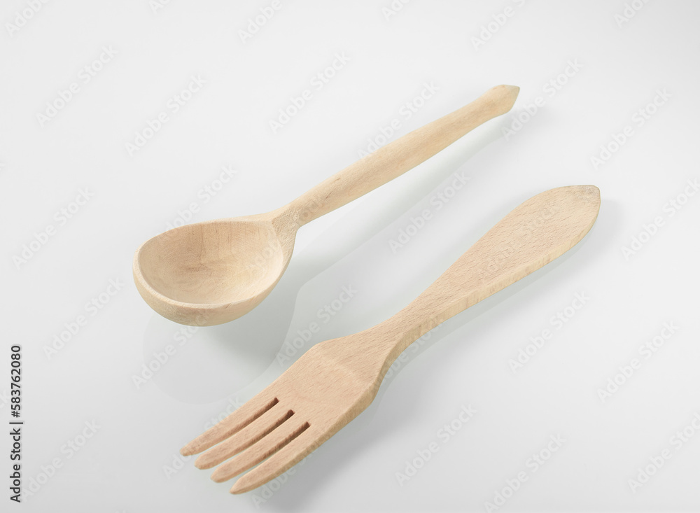 Wood kitchen utensils. Wooden spoon and fork on a white mirror background Wood kitchen utensils. Wooden spoon and fork on a white mirror background