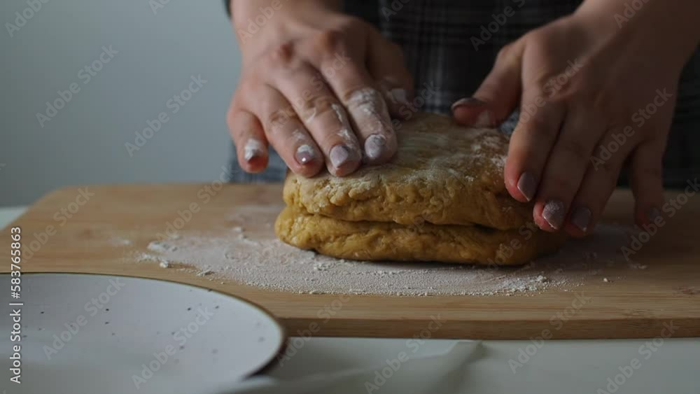 Woman is kneading dough on a wooden table. Home baking pastries. Preparing pie cake or handmade cookies for Easter. Cooking gingerbread for Christmas. Close up of female baker hands making biscuits. Woman is kneading dough on a wooden table. Home baking pastries. Preparing pie cake or handmade cookies for Easter. Cooking gingerbread for Christmas. Close up of female baker hands making biscuits.